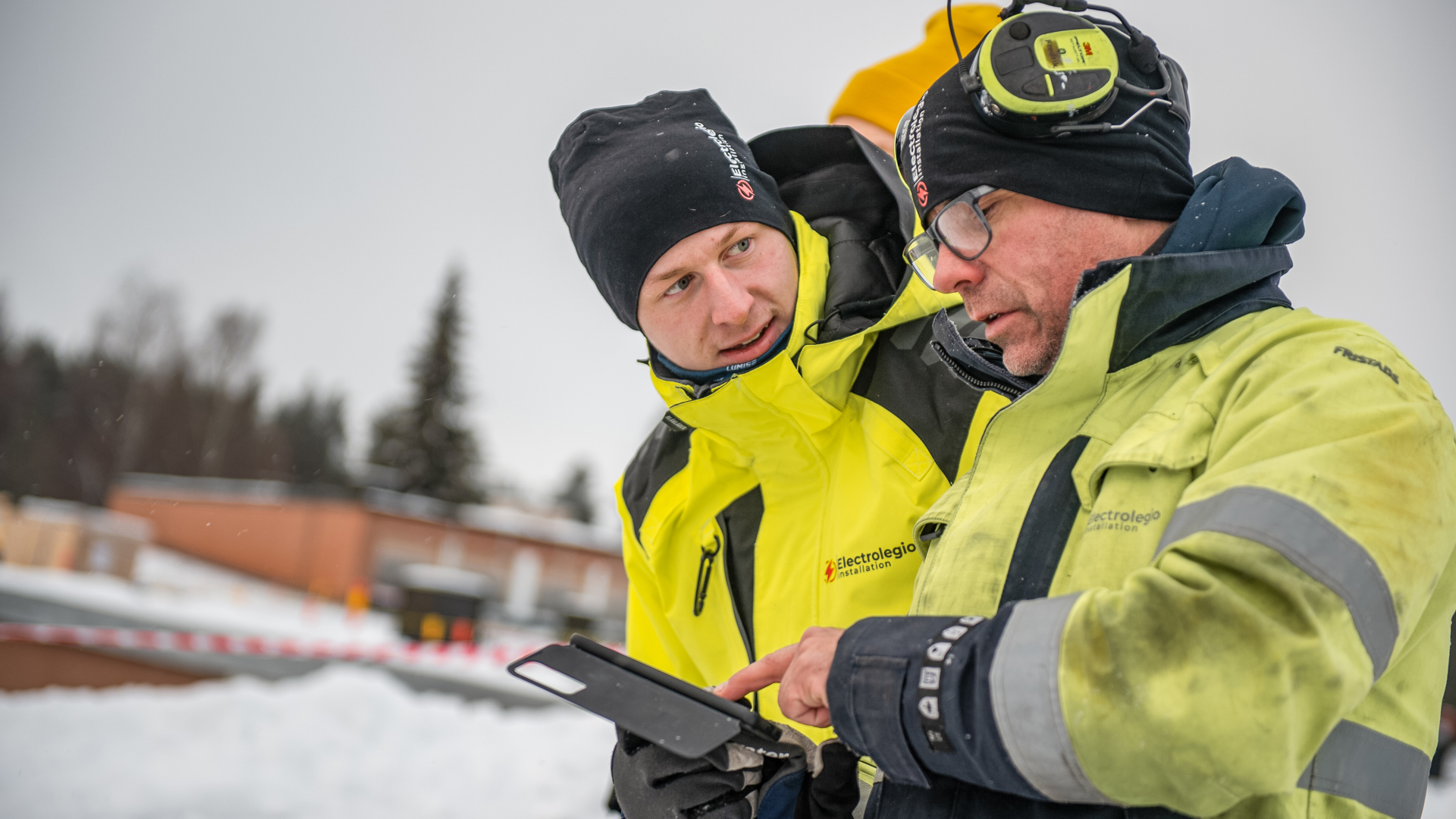 två personer ute i fält med att installera solpaneler